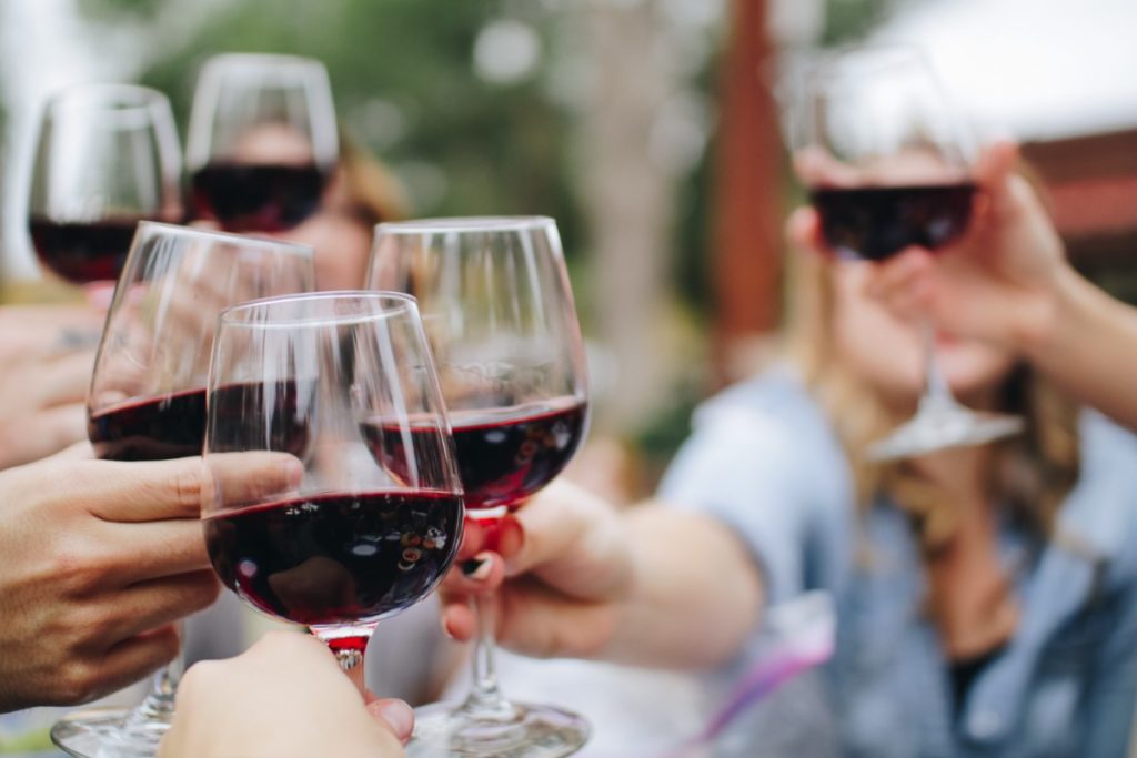Red wine glasses being raised in cheers